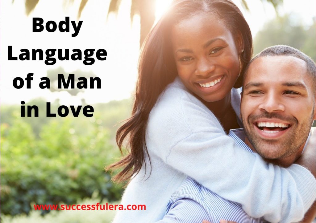 at= "A man wiith a woman to show a 'Body Language of a Man in Love' while smiling and backing the woman who is smiling too"