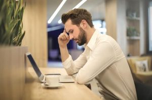 A man thinking which shows the signs your ex is thinking about you